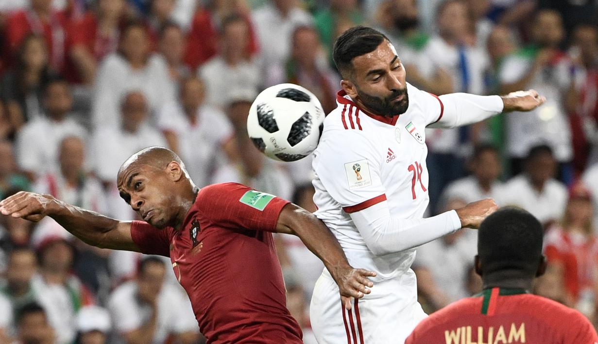 Duel pemain Portugal, Joao Mario (kiri) dan pemain Iran, Saman Ghoddos pada laga grup B Piala Dunia 2018 di Mordovia Arena, Saransk, Rusia, (25/6/2018). Portugal dan Iran bermain imbang 1-1. (AFP/Filippo Monteforte)