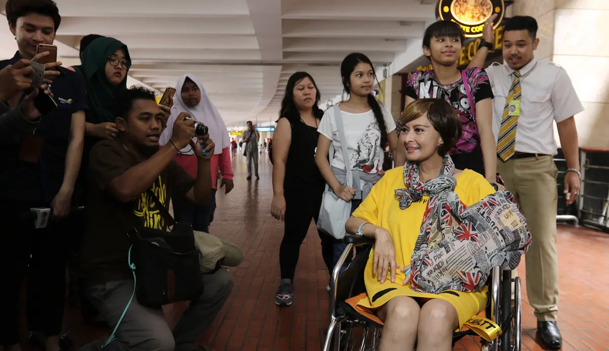 Sejumlah orang memotret Yana Zein saat tiba di bandara Bandara Soekarno Hatta, Tangerang, Minggu (28/5). Yana Zein kembali ke Tanah Air, setelah menjalani pengobatan kanker di Tiongkok. (Liputan6.com/Herman Zakharia)