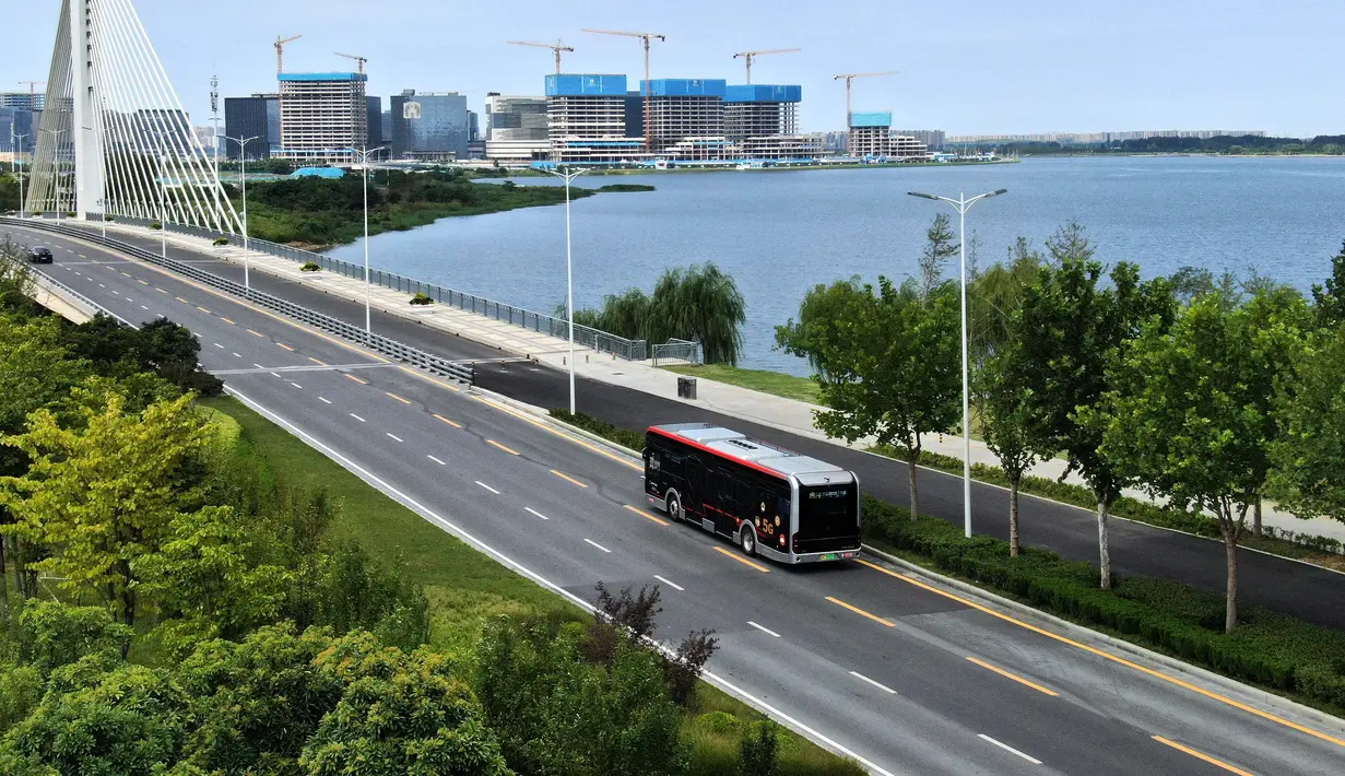Foto udara menunjukkan sebuah bus otonomos dari jalur bus autopilot 1 melintas di Zhengzhou, Provinsi Henan, China (18/8/2020). Bus autopilot ini menggabungkan sejumlah teknologi seperti layanan jaringan 5G dan kecerdasan buatan (AI) serta sistem pengawasan dan kendali cerdas. (Xinhua/Li An)