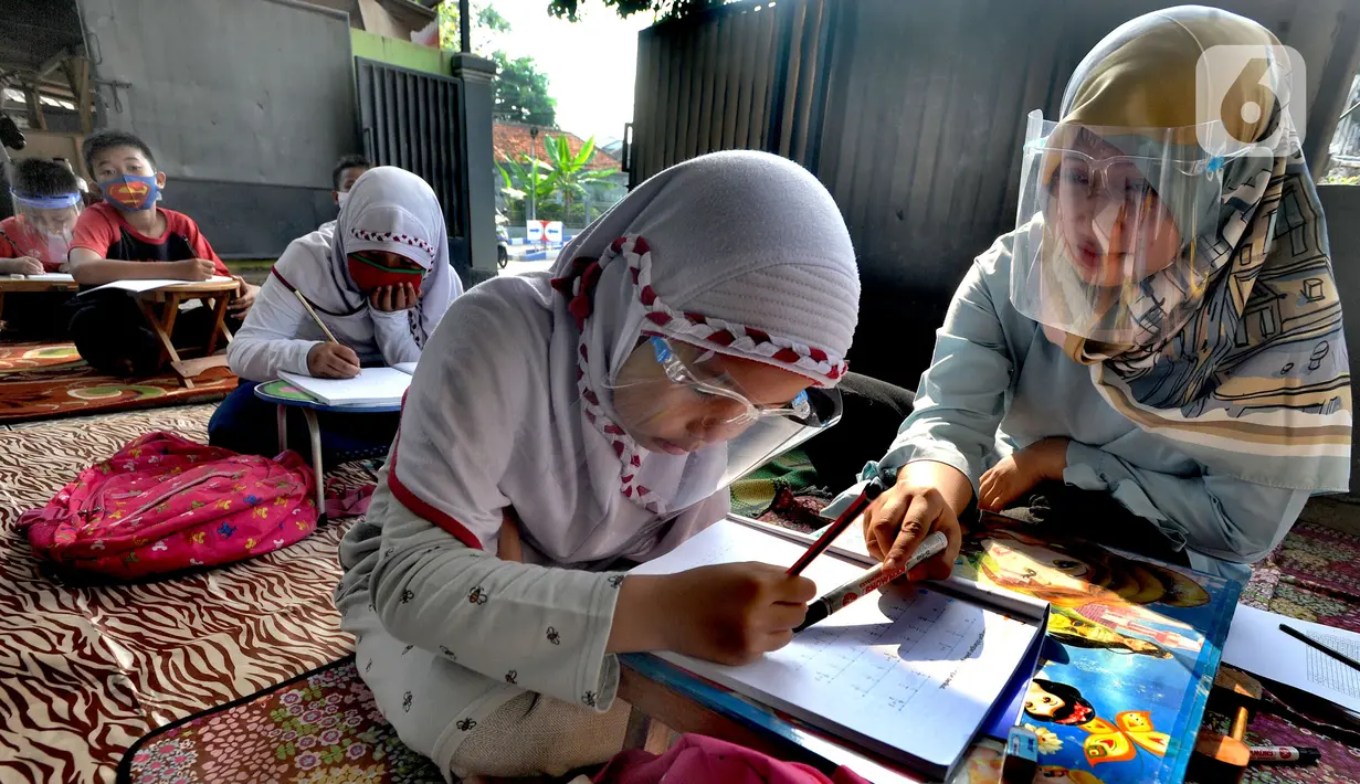 Murid kelas IV SD Muhammadiyah 37 belajar di teras rumah seorang guru di kawasan Pondok Cabe Udik, Tangerang Selatan, Banten, Senin (10/8/2020). Kegiatan belajar mengajar (KBM) tatap muka ini dilakukan karena murid kesulitan menguasai materi pelajaran saat belajar online. (merdeka.com/Arie Basuki)