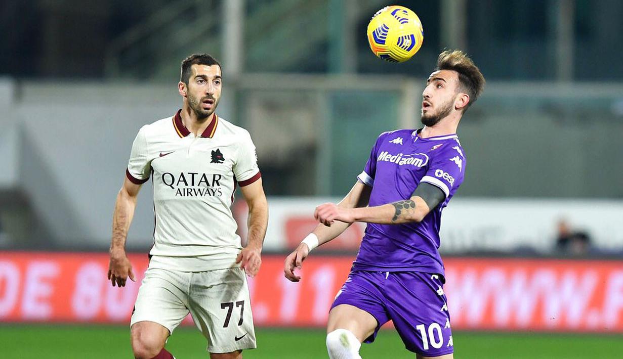 Pemain AS Roma, Henrikh Mkhitaryan, berebut bola dengan pemain Fiorentina, Gaetano Castrovilli, pada laga Liga Italia di Stadion Artemio Franchi, Rabu (3/3/2021). AS Roma menang dengan skor 2-1. (Jennifer Lorenzini/LaPresse via AP)