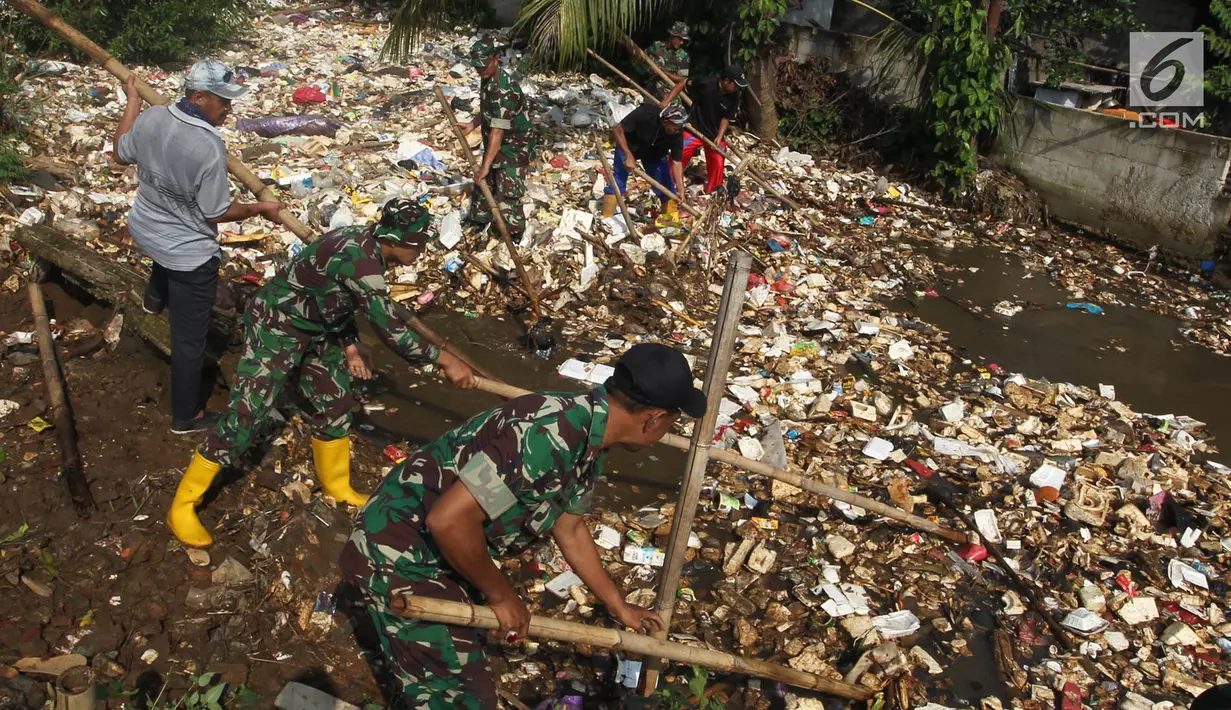 Anggota TNI bersama warga membersihkan  sampah yang menutupi aliran sungai di Kali Baru, Bojonggede, Bogor, Minggu (28/4/2019). Dinas Lingkungan Hidup (DLH) Kabupaten Bogor mengerahkan 50 truk sampah untuk membersihkan sampah yang terbawa banjir dua hari lalu. (merdeka.com/Arie Basuki)