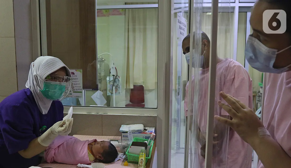 Pasangan orangtua baru memperhatikan saat perawat memberikan penjelasan dalam kegiatan pelatihan di RSIA Tambak, Jakarta, Kamis (18/02/2021). Melatih para ibu baru untuk memandikan bayi pertama tersebut dilakukan dengan menerapkan protokol kesehatan ketat. (Liputan6.com/Herman Zakharia)