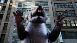 Balon tikus raksasa berjalan di tengah kota untuk diletakkan di luar kantor perusahaan di New York, Kamis (26/12/2019). Balon tikus itu sengaja ditempatkan di luar kantor sebuah pengembang di Manhattan yang dituduh tidak membayar upah pekerja bangunan non-serikat. (TIMOTHY A. CLARY/AFP)