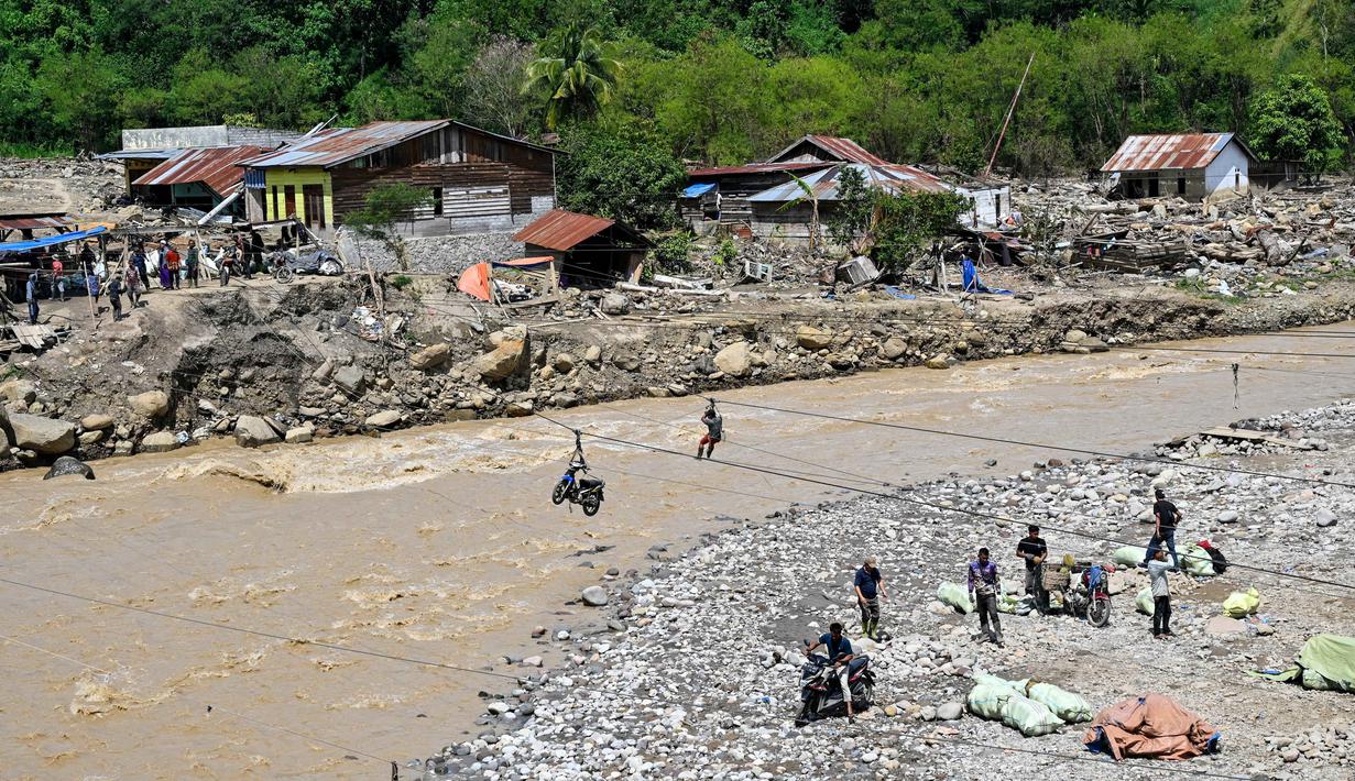 Meski berbahaya, tali sling menjadi satu-satunya cara agar mobilitas warga Aceh Tengah tetap berjalan. Tampak dalam foto, warga menggunakan tali untuk menyeberangi sungai setelah banjir bandang yang menghancurkan desa-desa di sekitarnya di Ketol, provinsi Aceh, pada Selasa 6 Januari 2026. (CHAIDEER MAHYUDDIN/AFP)