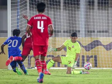 Kiper Timnas Indonesia, Ikram Al Giffari menghalau tendangan pemain Maladewa, Muzdhan Hassan (kiri) pada laga Grup F Kualifikasi Piala Asia U-20 2024 di Stadion Madya, Senayan, Jakarta, Rabu (25/09/2024). (Bola.com/Bagaskara Lazuardi)