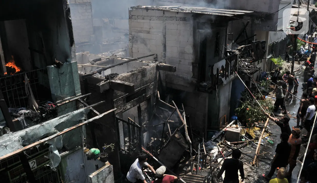 Warga bergotong royong memadamkan api yang membakar permukiman di Jalan Kebon Jeruk 13, Taman Sari, Jakarta Barat, Minggu (6/10/2019). Kebakaran menghanguskan puluhan rumah di dua kelurahan, Taman Sari dan Mapar. (merdeka.com/Iqbal Nugroho)