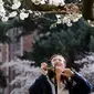 Wisatawan mengambil gambar bunga sakura yang bermekaran pada hari pertama musim semi di kampus Universitas Washington, Seattle, Selasa (20/3). Pohon-pohon sakura tersebut merupakan hadiah dari Jepang lebih dari seabad yang lalu. (AP/Elaine Thompson)
