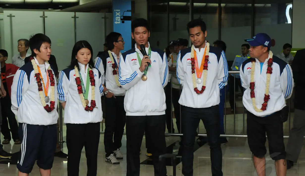 Pebulutangkis ganda campuran, Praveen Jordan (tengah) memberikan keterangan pada sejumlah pewarta sesaat setelah tiba di Bandara Soekarno-Hatta, Selasa (30/9/2014). (Liputan6.com/Helmi Fithriansyah)