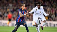 Gelandang Real Madrid, Eduardo Camavinga (kanan) menguasai bola di depan striker Bracelona, Raphinha pada laga leg kedua semifinal Copa del Rey 2022/2023 di Camp Nou Stadium, Barcelona (5/4/2023). Eduardo Camavinga baru memasuki musim kedua bersama Real Madrid sejak didatangkan pada awal musim 2021/2022. Hingga kini ia telah tampil dalam 90 laga di semua ajang bareng Los Blancos dengan torehan 2 gol dan 3 assist. (AFP/Pau Barrena)