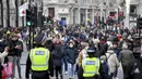 Orang-orang berjalan dengan mengenakan masker dan membawa tas belanjaan di Regent Street, setelah pelonggaran pembatasan virus corona COVID-19 menyusul berakhirnya kebijakan penguncian nasional atau lockdown kedua di Inggris, di London, Sabtu (5/12/2020). (AP Photo/Alberto Pezzali)