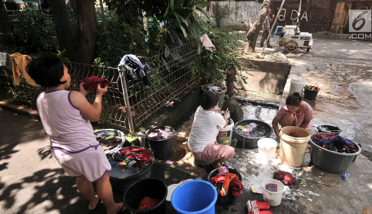 Warga mencuci pakaian di pinggir jalan kawasan Kramat Pulo, Senen, Jakarta, Kamis (27/12). Meski hanya menggunakan pompai air manual, warga Kramat Pulo mengaku nyaman mencuci di pinggir jalan karena gratis. (Merdeka.com/Iqbal S. Nugroho)