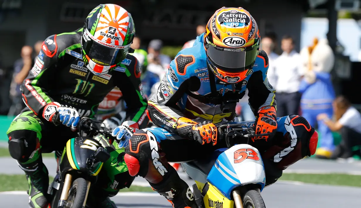 Pembalap MotoGP Tito Rabat beradu cepat dengan Johann Zarco saat mengikuti balapan motor listrik mini di sirkuit Twin Ring Motegi, Jepang (12/10). (AP Photo / Shizuo Kambayashi)