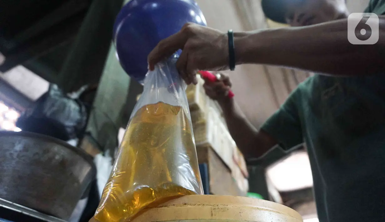 Pedagang memasukan minyak goreng curah ke plastik di Pasar Senen, Jakarta, Selasa (31/5/2022). Kementerian Perindustrian mencabut subsidi minyak goreng curah kepada pelaku usaha mulai Selasa (31/5/2022). (Liputan6.com/Herman Zakharia)