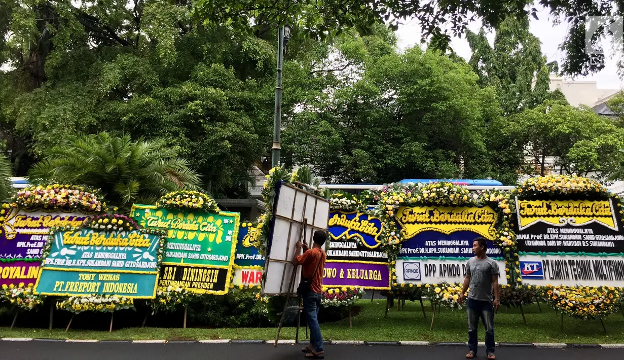 Pekerja menaruh karangan bunga untuk almarhum Sukamdani Sahid di sekitar pinggir Jalan Imam Bonjol, Jakarta, Kamis (21/12). Upacara militer almarhum Sukamdani dilaksanakan di Pondok Pesantren Modern Sahid, Bogor. (Liputan6.com/Immanuel Antonius)