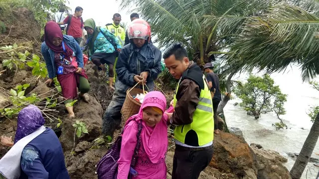Emak-emak panik saat tembus sisa longsor yang menutupi jalan poros trans sulawesi di Kabupaten Majene, Sulsel (Liputan6.com/ Eka Hakim)