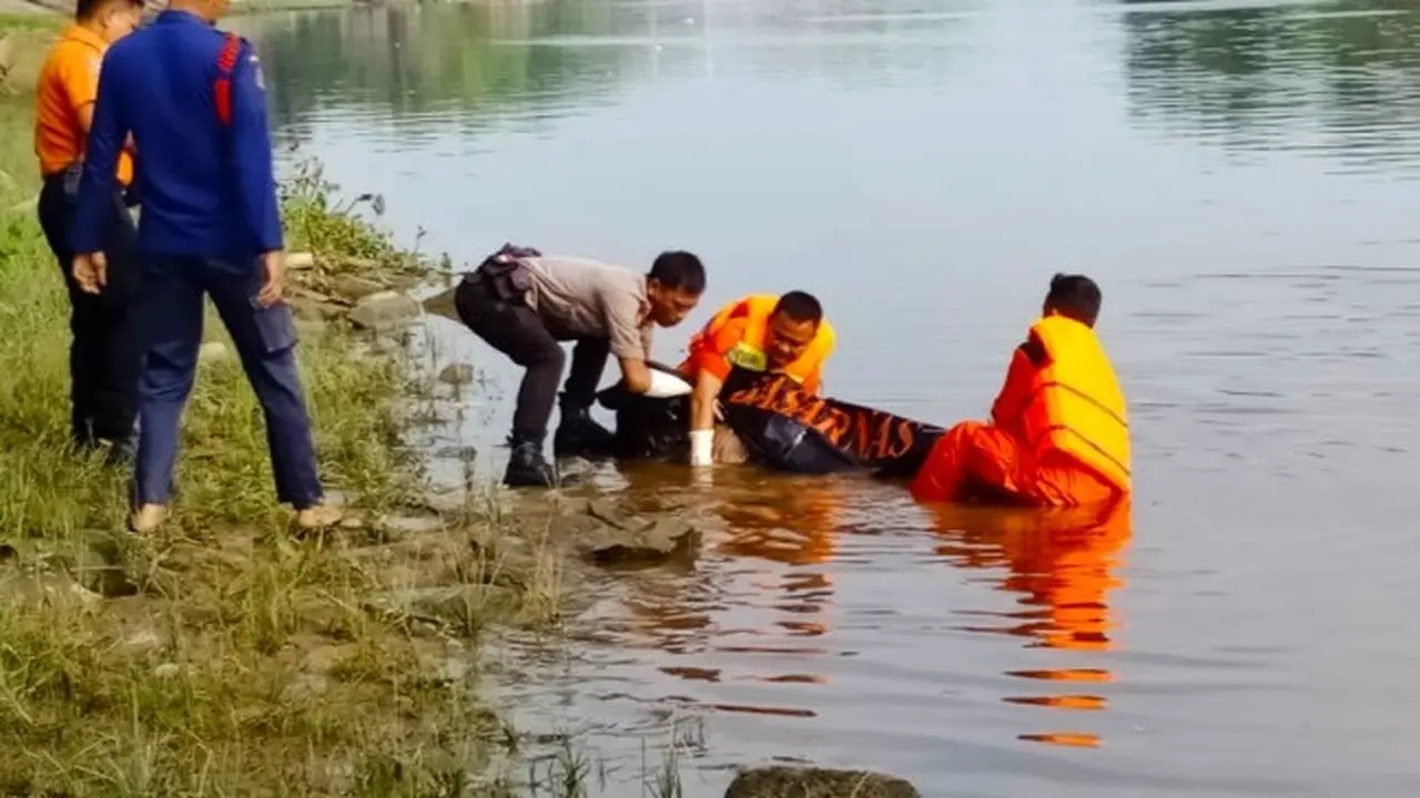 Petugas mengevakuasi jenazah Suhartini dari Sungai Siak, Pekanbaru.