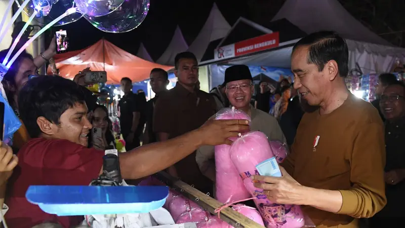 Presiden Joko Widodo jajan gulali saat mengunjungi Festival Tabut 2023 di Lapangan Merdeka Bengkulu Provinsi Bengkulu, Rabu (19/7/2023). (Foto: Kris - Biro Pers Sekretariat Presiden)