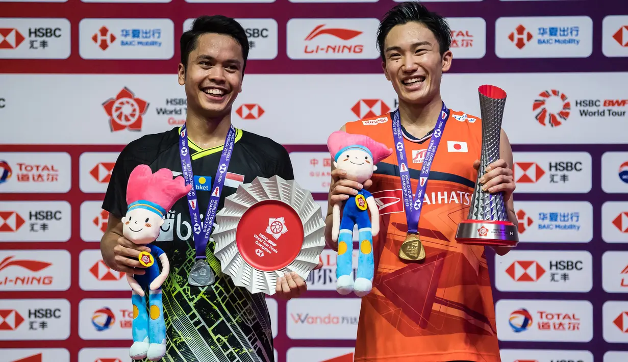 Juara BWF World Tour Finals, Kento Momota dari Jepang dan runner-up tunggal putra Indonesia Anthony Sinisuka Ginting berfoto bersama usai penyerahan medali pada pertandingan final di Tianhe Gymnasium, Guangzhou, China, Minggu (15/12/2019). Anthony takluk dengan skor 21-17, 17-21, 14-21. (STR/AFP)