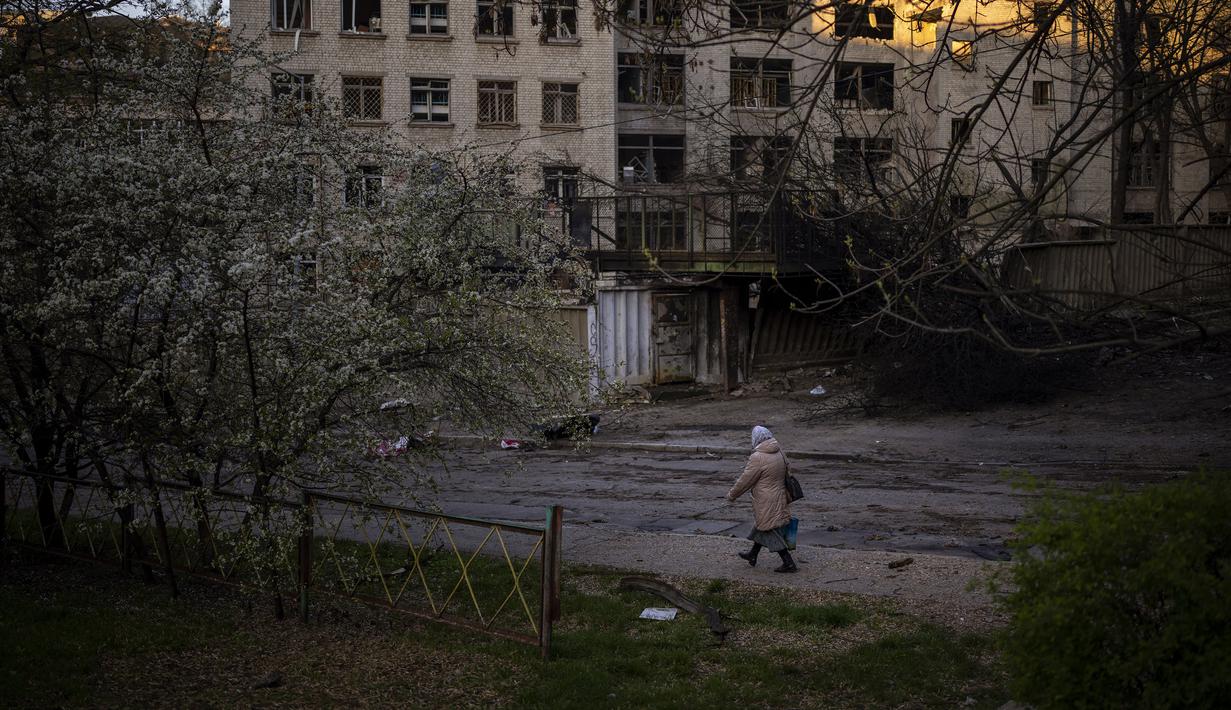 <p>Seorang wanita berjalan melewati lokasi ledakan di Kiev, Ukraina, Jumat (29/4/2022). Rusia menyerang Kiev tak lama setelah pertemuan antara Presiden Ukraina Volodymyr Zelenskyy dan Sekretaris Jenderal PBB António Guterres pada Kamis malam. (AP Photo/Emilio Morenatti)</p>