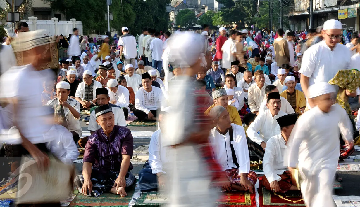 Suasana salat Idul Fitri 1436 H di ruas Jalan Jatinegara Barat, Jakarta, Jumat (17/7/2015). Usai melakukan salat Id sejumlah warga langsung bergegas untuk bersilaturahmi dengan para kerabat. (Liputan6.com/Johan Tallo)