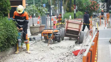 Pekerja membongkar jalur pejalan kaki (trotoar) di Jalan Cikini Raya, Jakarta, Jumat (14/6/2019). Pemprov DKI bakal melakukan revitalisasi  trotoar di Jalan Cikini Raya dan Jalan Kramat Raya sepanjang 10 kilometer dengan anggaran sebesar Rp75 miliar. (Liputan6.com/Immanuel Antonius)