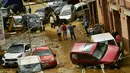 Warga berkumpul di jalan dekat mobil yang rusak setelah banjir bandang menerjang Tafalla, Spanyol, Selasa (9/7/2019). Hujan deras menyebabkan dua sungai meluap dan menimbulkan banjir bandang. (AP Photo/Alvaro Barrientos)