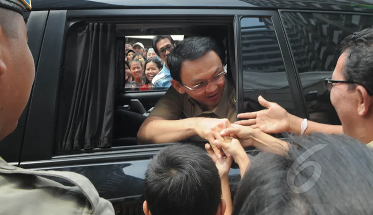 Gubernur DKI Jakarta Basuki "Ahok" Tjahaja Purnama menjadi sasaran rebutan warga untuk bersalaman seusai meresmikan pengoperasian rusunawa Tambora, Jakarta Barat, Selasa (24/2/2015). (Liputan6.com/Herman Zakharia)