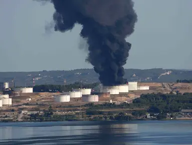 Kepulan asap hitam membumbung ke angkasa di kilang minyak milik perusahaan Amerika LyondellBasell yang terbakar di Etang de Berre, Marseille, Perancis, (14/7/2015). Tidak ada korban jiwa akibat kebakaran yang terjadi. (REUTERS/Philippe Laurenson)