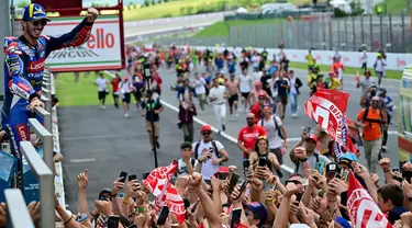 Pembalap Ducati Lenovo, Francesco Bagnaia melakukan selebrasi dengan para penggemarnya usai memenangi balapan MotoGP Italia di Mugello, 2 Juni 2024. (Marco BERTORELLO/AFP)