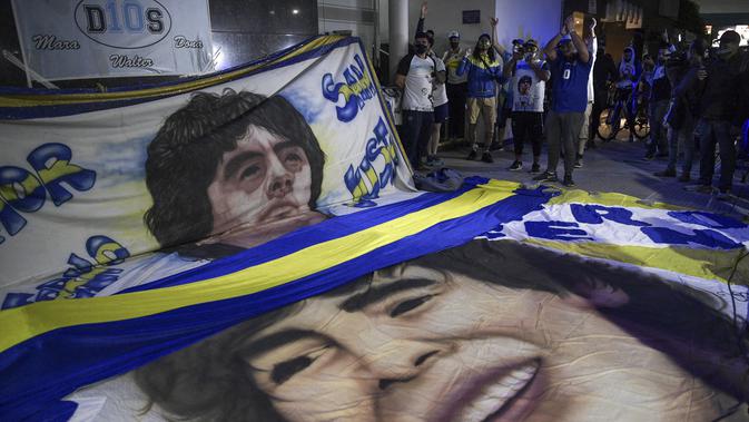 Para penggemar mantan bintang sepak bola Argentina, Diego Maradona berkumpul di luar rumah sakit tempatnya akan menjalani operasi di Olivos, Buenos Aires, Selasa (3/11/2020). Diego Maradona menjalani operasi hematoma subdural atau pembekuan darah di otak. (JUAN MABROMATA / AFP)