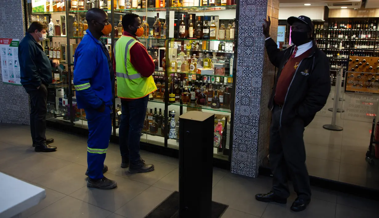 Pelanggan menunggu pembukaan kembali toko minuman keras ketika Afrika Selatan mencabut larangan penjualan alkohol dan rokok di Johannesburg, Selasa (18/8/2020). Pembelian alkohol dan rokok dilarang ketika Afrika Selatan memberlakukan lockdown ketat pada 27 Maret 2020. (AP Photo/Denis Farrell)
