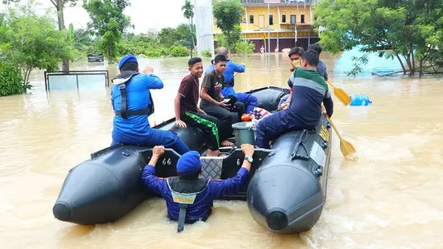 Personel Polda Riau membantu evakuasi warga korban banjir di Pekanbaru.