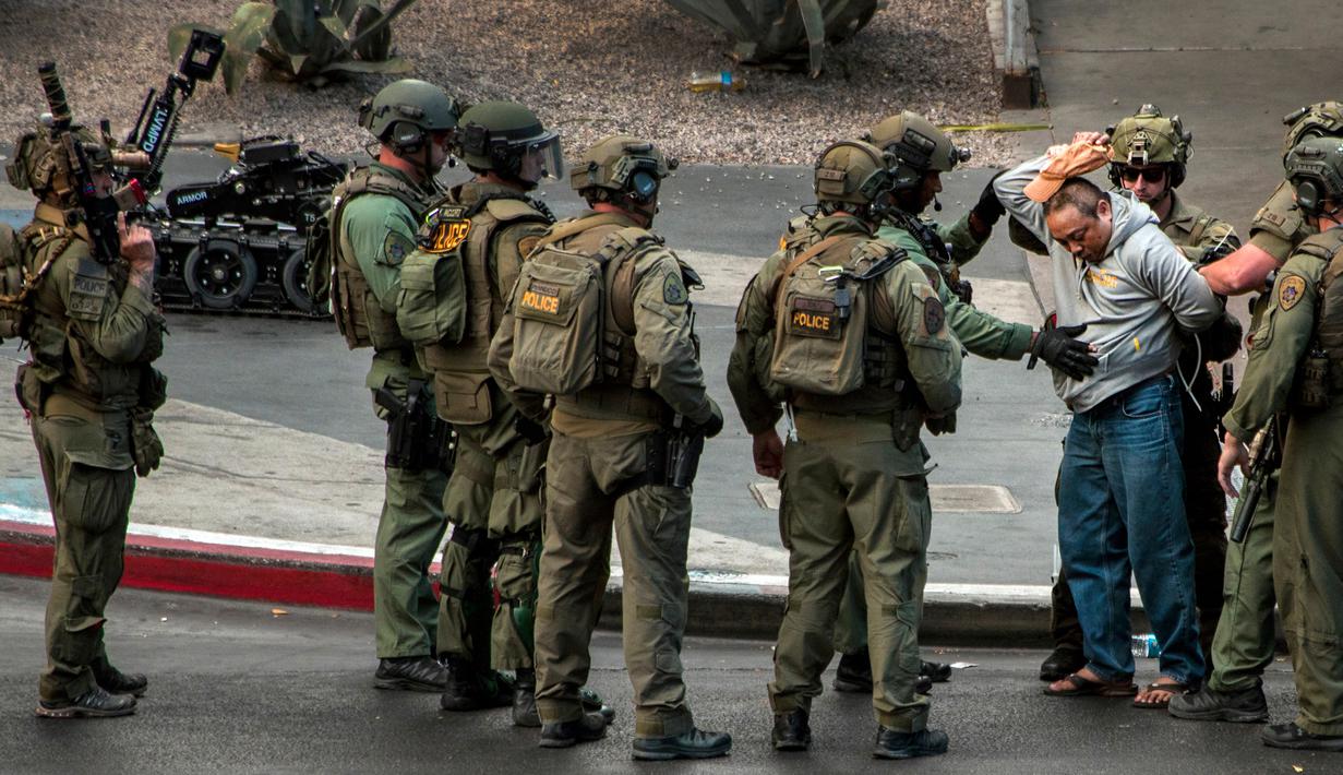 Seorang pelaku menyerahkan diri seusai melakukan aksi penembakan di dekat hotel sekaligus kasino terkemuka Cosmopolitan, Las Vegas, Sabtu (25/3). Pelaku sempat bersembunyi di dalam sebuah bus tingkat selama berjam-jam. (L.E. Baskow/Las Vegas Sun via AP)