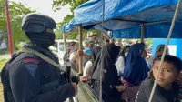 Seorang petugas brimob polda Jabar tengah memberikan pengamanan bagi pengunjung di kawasan Pantai Sayang Heulang, Cikelet, Garut. (Liputan6.com/Jayadi Supriadin)