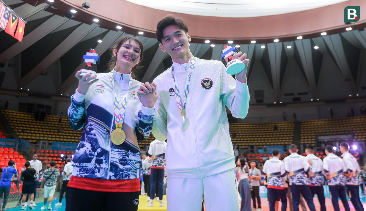 Pasangan pevoli Indonesia, Alfin Daniel Pratama dan penerjemah timnas voli putra Thailand, McEntee Catherine kedapatan saling memberikan dukungan meski mereka berbeda tim. Meskipun begitu, keduanya tetap fokus memberikan usaha yang terbaik untuk tim mereka. (Bola.com/Bagaskara Lazuardi)
