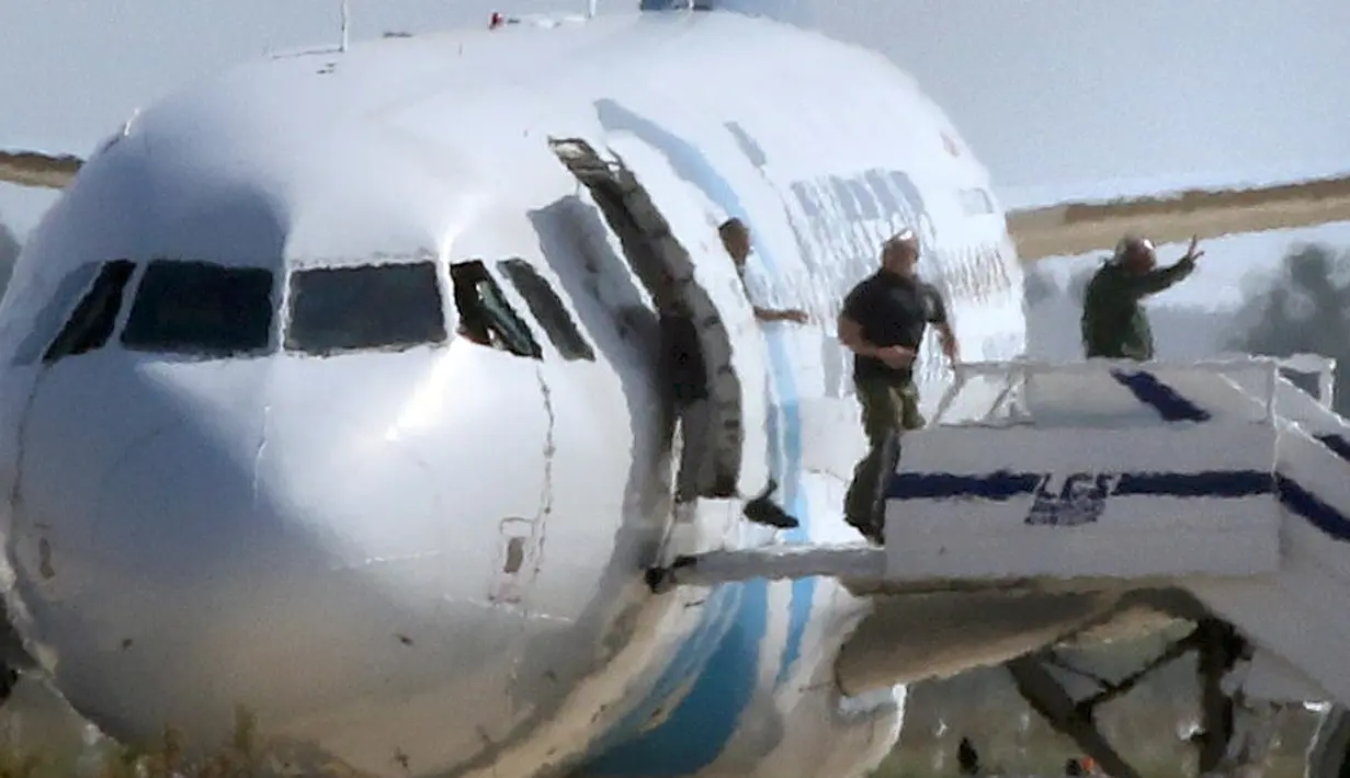 Sandera mengangkat tangan saat menuruni pesawat EgyptAir setelah dibebaskan pelaku, Siprus, Selasa (29/3). Pelaku yang diketahui bernama Seif Eldin Mustafa (27) menyerahkan diri dan membebaskan 5 sandera. (Reuters/Yiannis Kourtoglou)