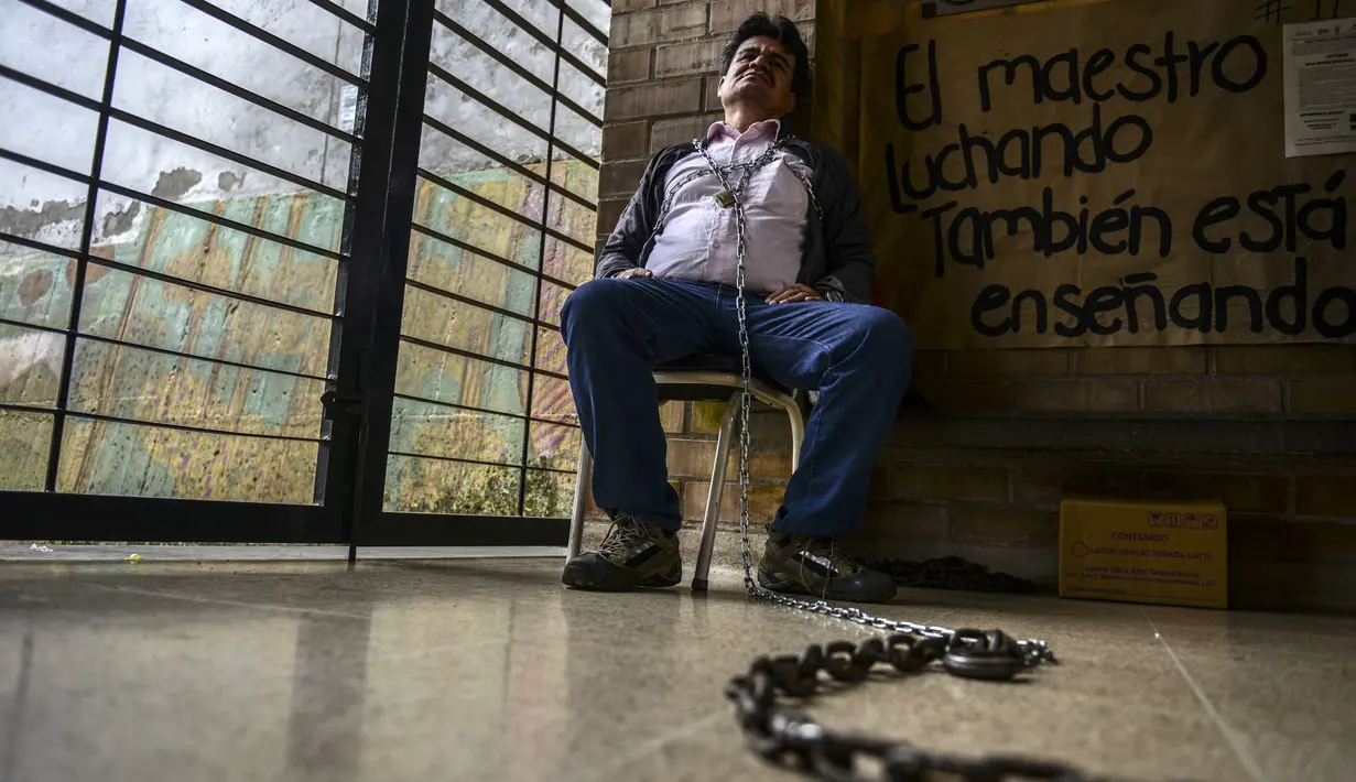 Seorang Guru, Carlos Freddy Guisao merantai dirinya di Sekolah Jorge Robledo selama sembilan hari saat melakukan aksi menuntut perbaikan sistem pendidikan, upah yang lebih tinggi baik di Medellin, Kolombia, (7/6). (AFP Photo/Joaquin Sarmiento)