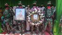 Prajurit TNI memegang foto Pelda Anumerta Rama Wahyudi sebelum dimakamkan di Pekanbaru. (Liputan6.com/M Syukur)