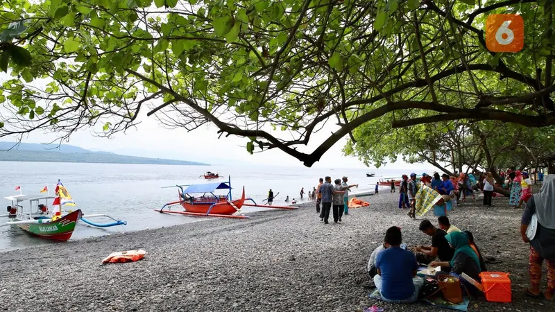 Para Wisatawan sedang menikmati libur panjang Hari Raya Idul Fitri di Pantai GWD Banyuwangi. (Hermawan Arifianto/ Liputan6.com )