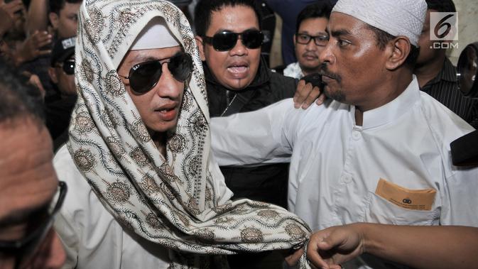 Habib Bahar bin Smith dikerumuni awak media saat tiba untuk menjalani pemeriksaan di Gedung Bareskrim Polri Jakarta, Kamis (6/12). Habib Bahar bin Smith tampil mengenakan kacamata hitam saat memenuhi panggilan Bareskrim. (Merdeka.com/ Iqbal S. Nugroho)