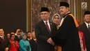 Ketua DK OJK yang baru, Wimboh Santoso bersalaman dengan Ketua Mahkamah Agung (MA) Hatta Ali usai pelantikan di Jakarta, Kamis (20/7). (Liputan6.com/Angga Yuniar)