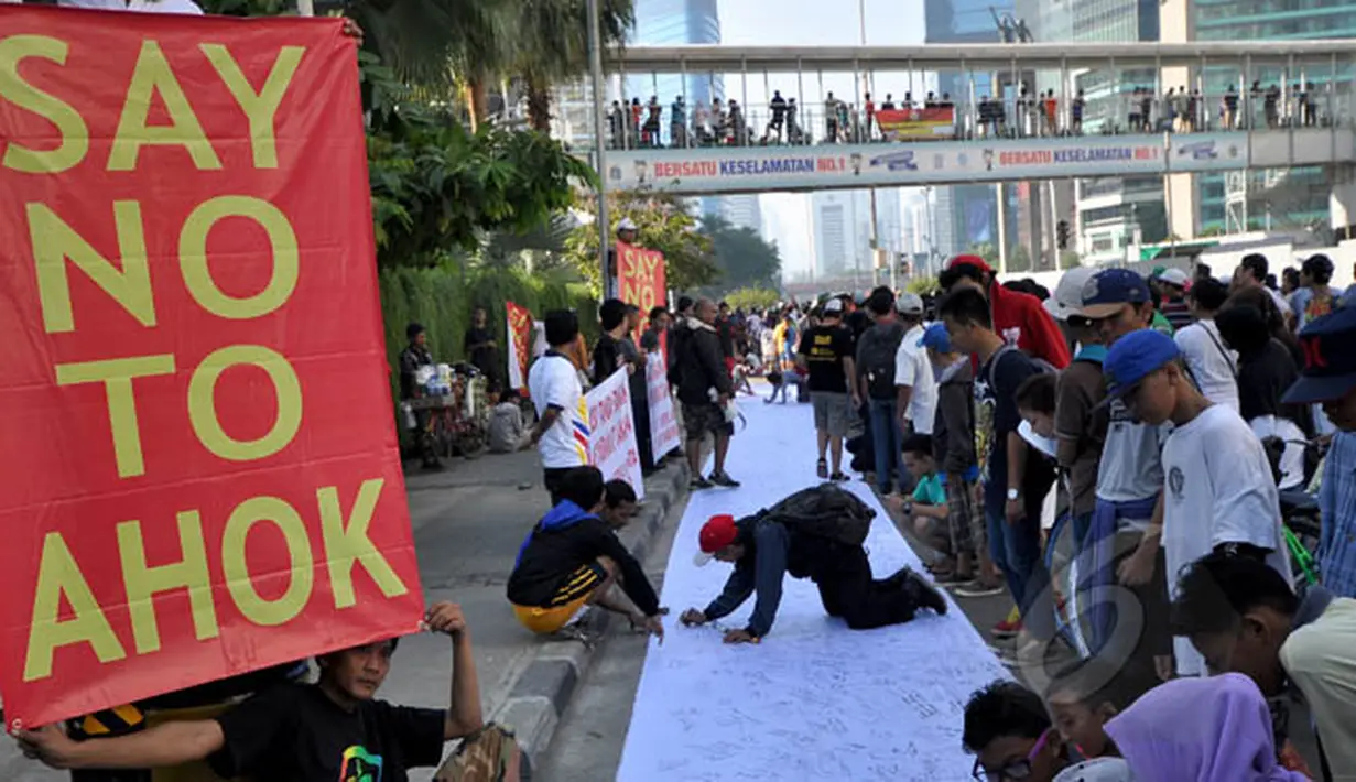 Sejumlah warga membubuhkan tanda tangan mendukung pemakzulan Gubernur DKI Basuki Tjahaja Purnama alias Ahok di Bundaran HI, Jakarta, Minggu (22/2/2015). Mereka melakukan aksi ini karena kebijakan Ahok dinilai tak pro-rakyat. (Liputan6.com/Faizal Fanani)