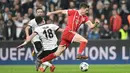 Robert Lewandowski (kanan) mencoba melewati adangan pemain Besiktas, Tolgay Arslan pada leg kedua 16 besar Liga Champions di Vodafone Stadyumu, Besiktas Park, Istanbul, (14/3/2018). Bayern menang 3-1. (AFP/Ozan Kose)