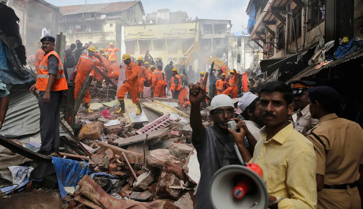 Petugas penyelamat berusaha mencari korban yang tertimbun akibat runtuhnya bangunan di Mumbai, India (31/8). Menurut pejabat setempat, sekitar 40 orang terjebak dalam reruntuhan bangunan tersebut. (AP Photo / Rafiq Maqbool)