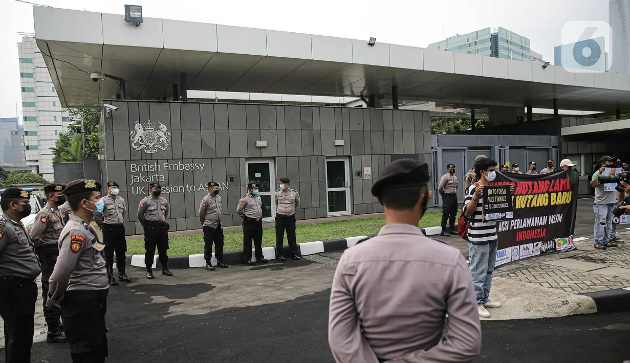Petugas kepolisian berjaga saat aksi protes aktivis di depan Kedubes Inggris, Jakarta, Rabu (3/11/2021). Pendanaan iklim tersebut merupakan kewajiban sebagian besar negara anggota G20 berdasarkan andilnya dalan emisi historis. (Liputan6.com/Faizal Fanani)