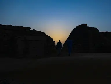 Seorang pengunjung berjalan di antara piramida Meroe di situs arkeologi Meroe di Bejrawiya, Sudan, Sabtu, 1 Agustus 2026. (Foto AP/Mohnd Blal)