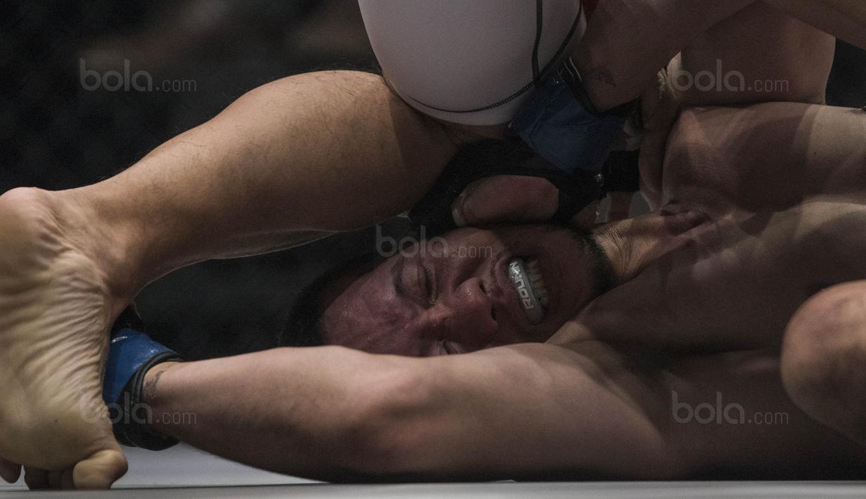 Petarung Indonesia, Yohan Legowo, kesakitan terkena kaki Victorio Senduk saat laga One Championship di JCC Senayan, Jakarta, Sabtu (20/1/2018). Yohan berhasil mengalahkan Victorio. (Bola.com/Vitalis Yogi Trisna)
