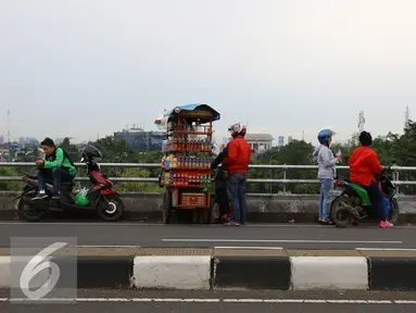 Pengendara sepeda motor menepikan kendaraannya di atas jalan layang Pasar Rebo, Jakarta, Sabtu (14/1). Setiap hari, jalan layang tersebut menjadi tempat untuk menghabiskan waktu bagi warga sekitar serta pemotor. (Liputan6.com/Immanuel Antonius)