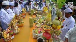 Umat Hindu mepersiapkan sesajen saat melaksanakan ritual Melasti di Kawasan Pantai Marina, Semarang, Jawa Tengah, Minggu (11/3). Melasti bertujuan untuk membersihkan diri dari segala bentuk perbuatan buruk di masa lalu. (Liputan6.com/Gholib)